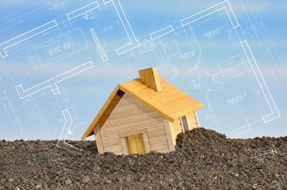 Permis de bâtir: plan de maison miniature en bois sur sol avec fond de plans d'architecture